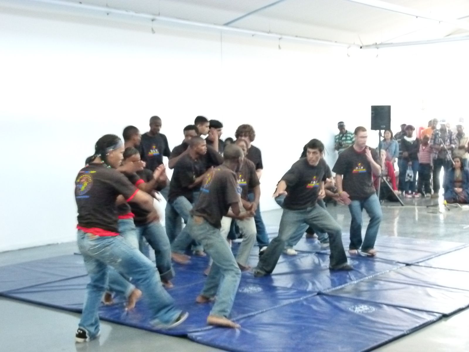 Trainees performing a choreographed street fight on blue mats
