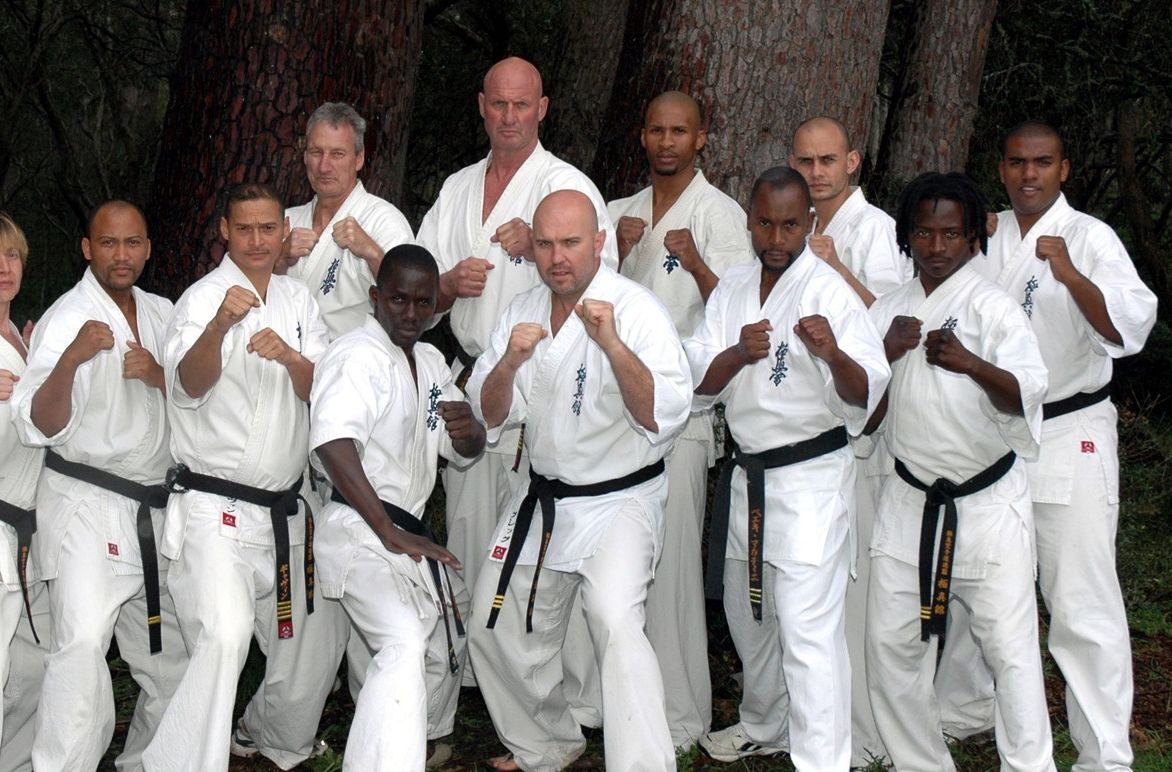 A Kyokushin-kan group in white gis lined up in a fighting stance