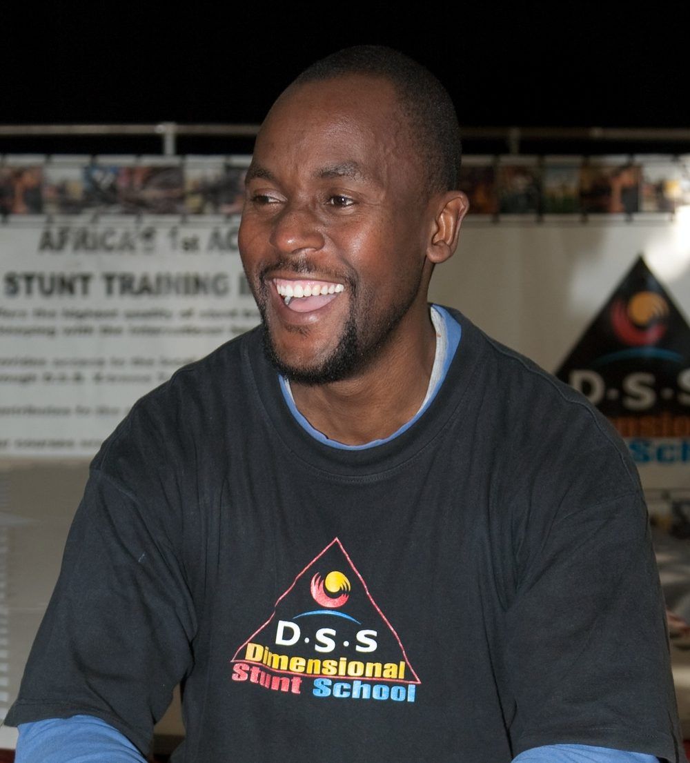 Sensei San Ndlovu smiling, wearing a Dimensional Stunt School T-shirt