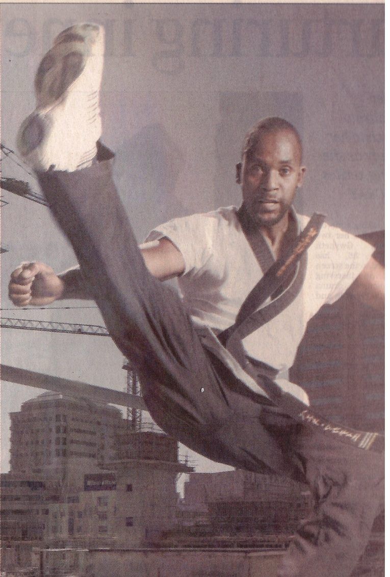 Sensei San Ndlovu in a high kick above the Cape Town skyline